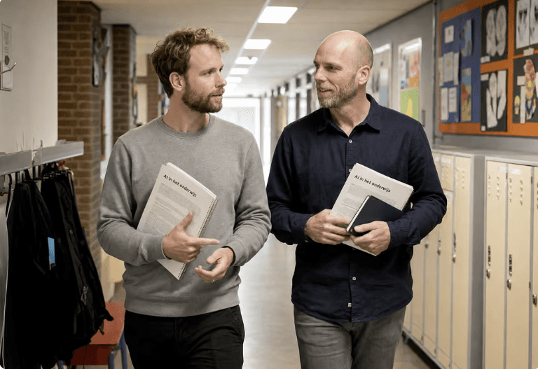 Twee onderwijsprofessionals in gesprek in een schoolgang